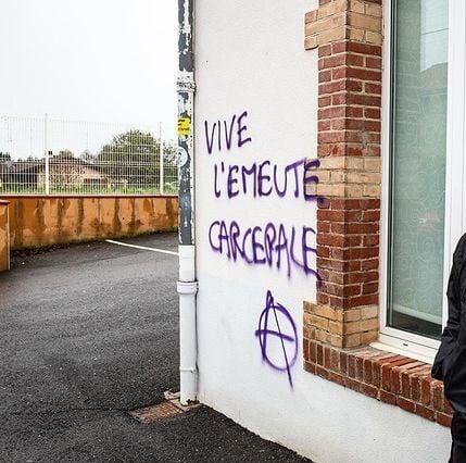 tags "Vive l'émeute carcérale" avec un symbole anarchiste